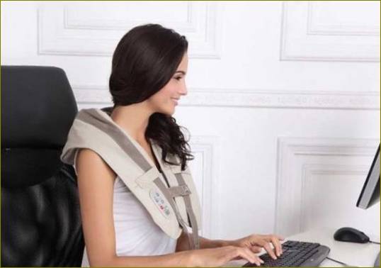 Djevojka radi za računalom s masažerom za ramena